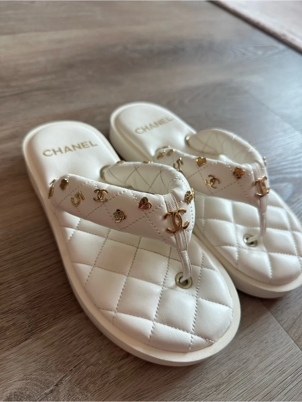 CHANEL 23S White Quilted Logo Flip Flops with Gold Charms